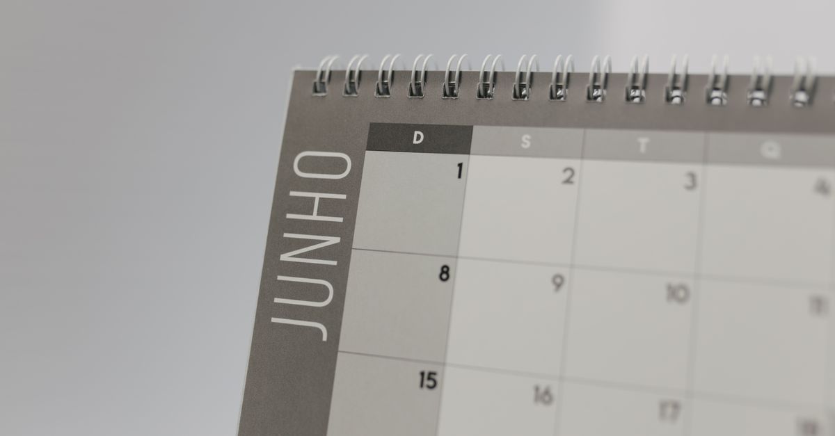 The corner of a grey spiral desk calendar shows the first days of June, with the month name printed down the side.