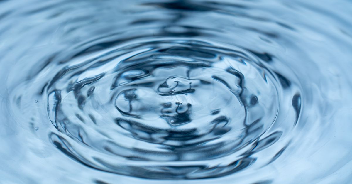 Concentric ripples spread outward across a blue water surface.