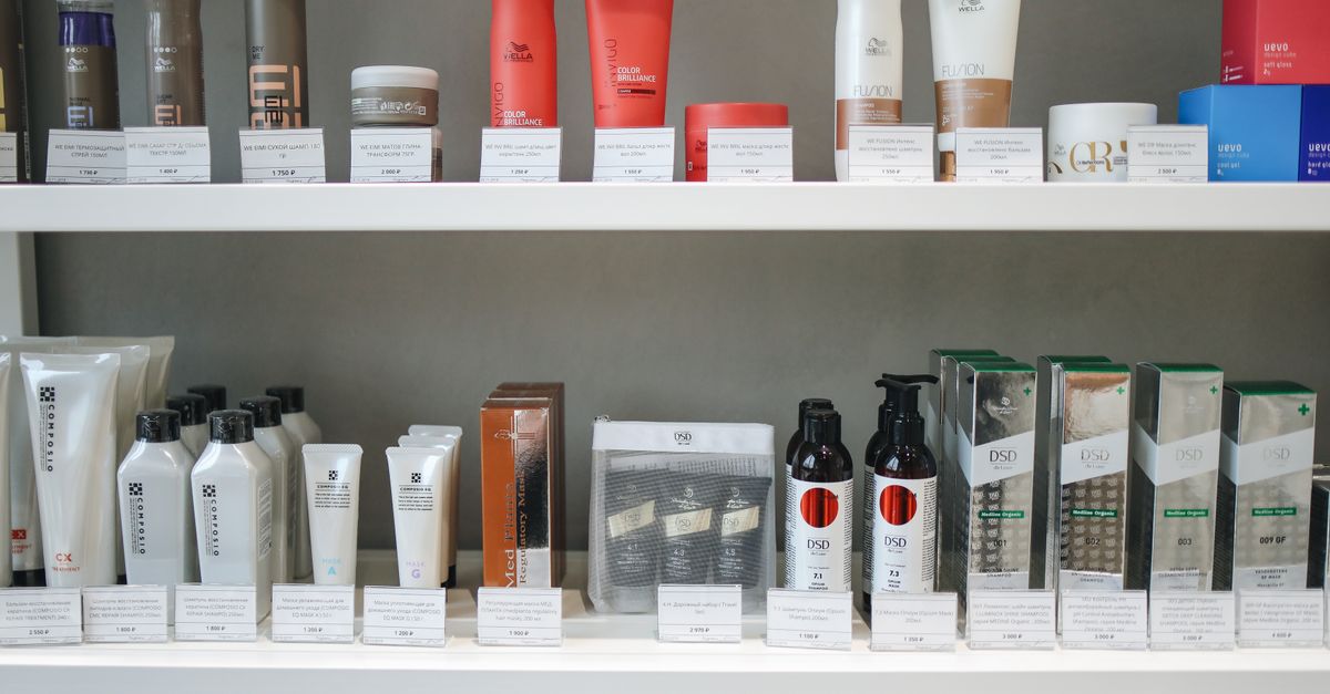 Rows of skincare bottles and jars lined up on bright white store shelves.